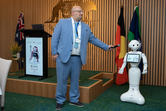 Dr Max Cappuccio speaks to a robot at Expo 2020. 